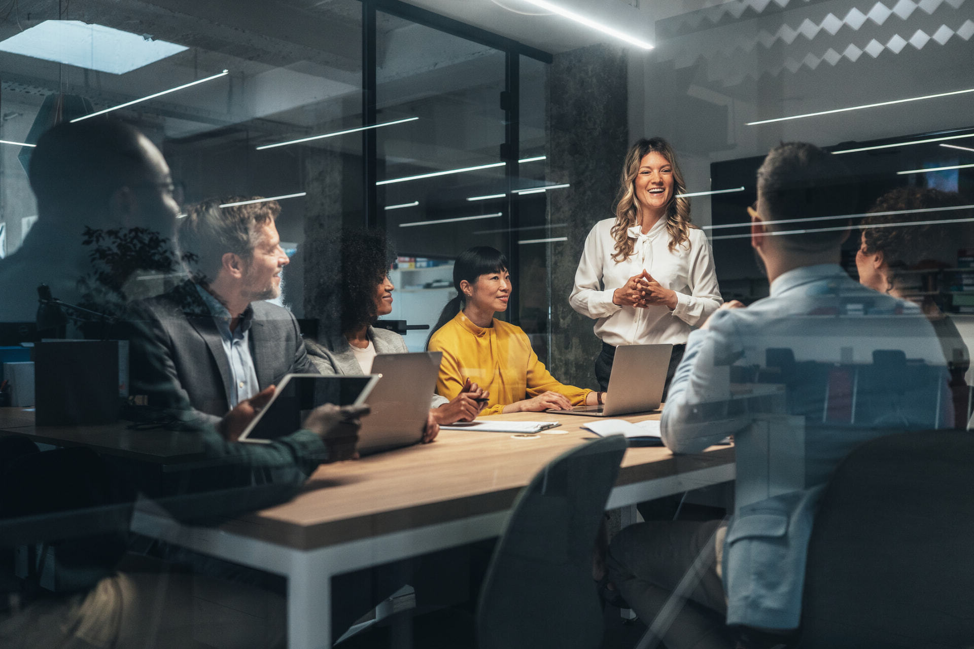 A smiling advisor in conversation with colleagues